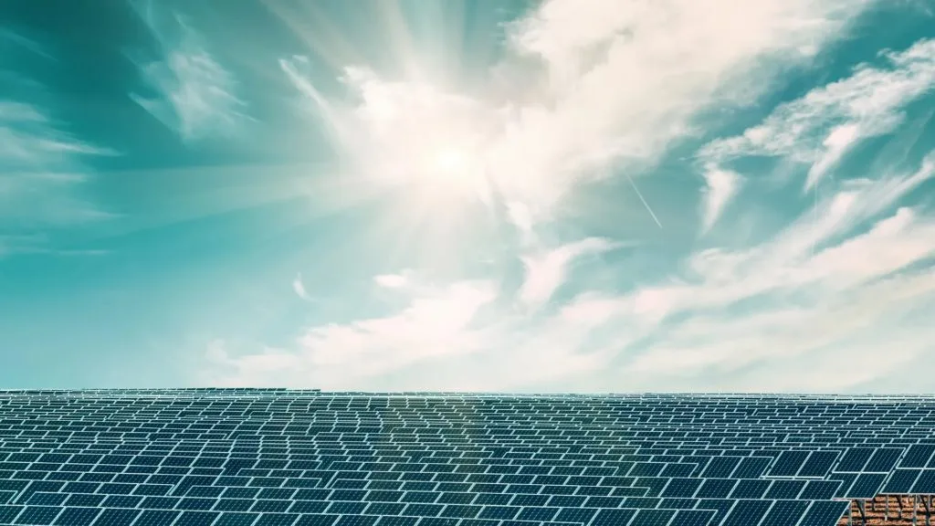 Close-up of a solar panel array under a bright sun and blue sky